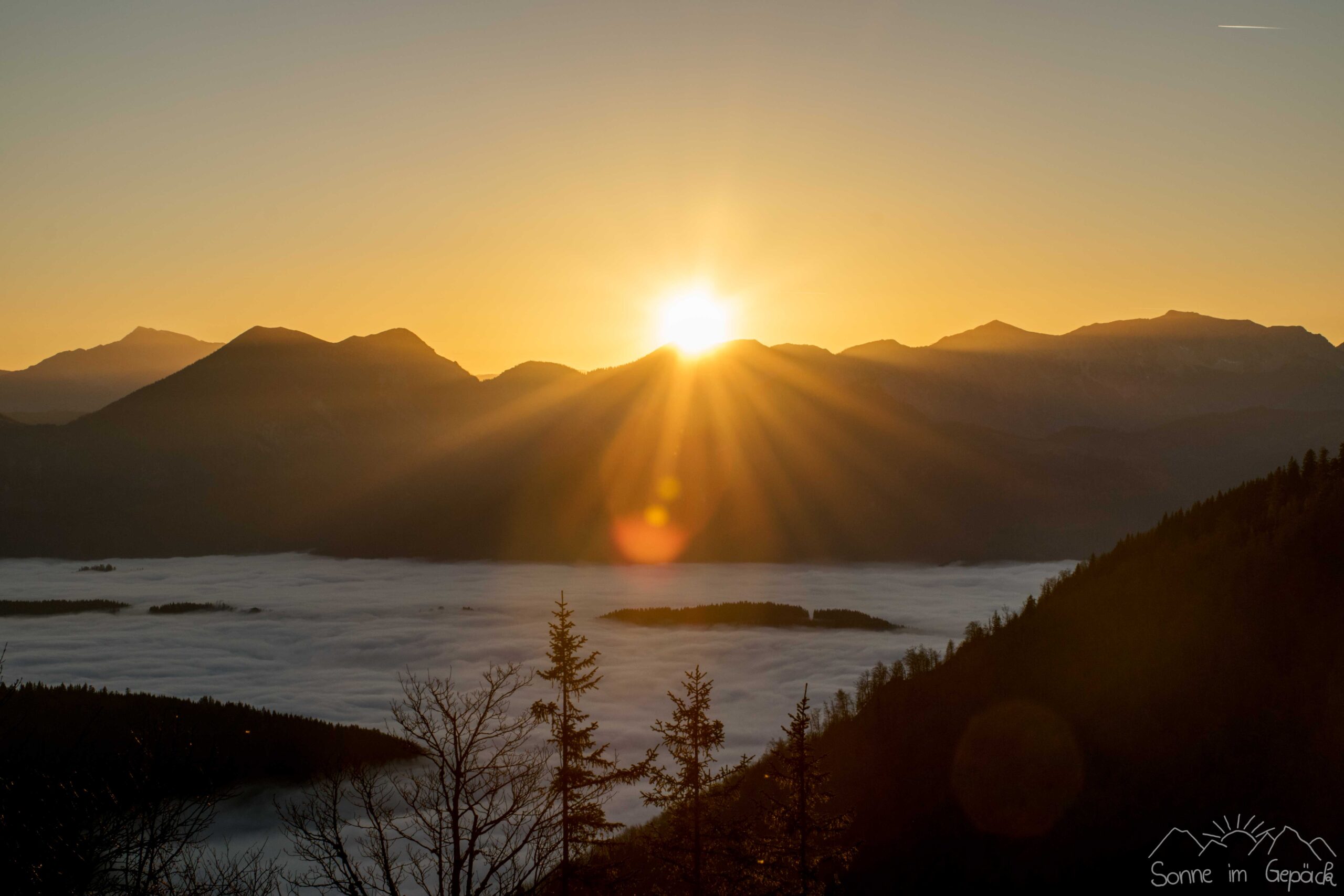 Bergkette mit Sonnenstrahlen.